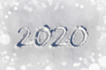 2020 written with a finger on a snow field in winter. Symbol of the year.