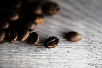 closeup coffee beans on light wood background texture.