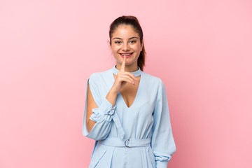 Young brunette girl over isolated pink background doing silence gesture