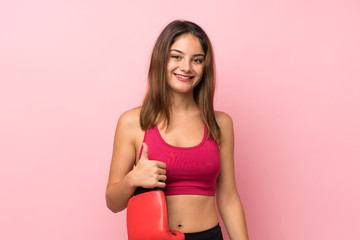 Young sport girl over isolated pink background with boxing gloves