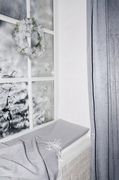 Vertical shot of windowsill for sitthing, warm blanket, fosty window.Winter season and cozy sitting room