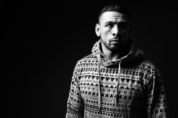 Young muscular Hispanic man against black background