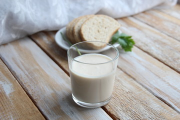 glass of ayran and grain bread on wooden table