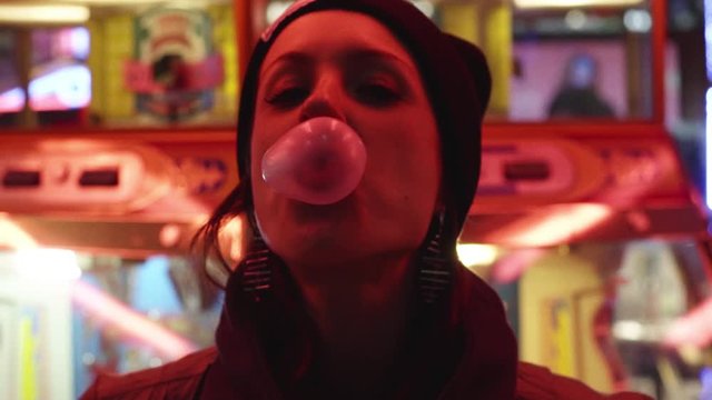 primo piano di ragazza che fa un palloncino con la gomma da masticare al luna park