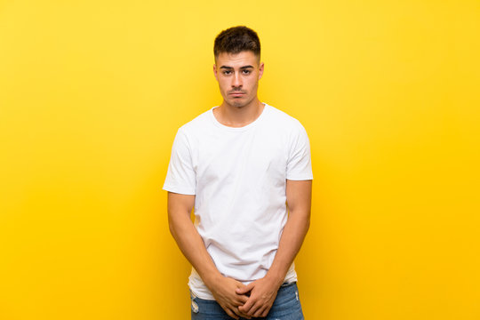 Young Handsome Man Over Isolated Yellow Background With Sad And Depressed Expression