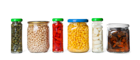 Different jars with pickled vegetables on white background
