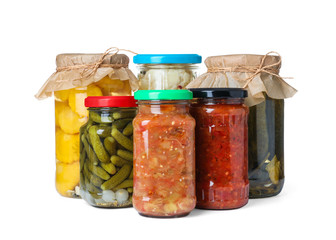 Different jars with pickled vegetables on white background