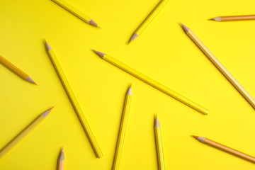 Flat lay composition with color pencils on yellow background