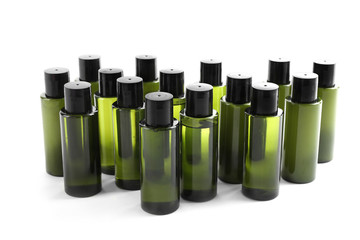 Mini bottles with cosmetic products on white background