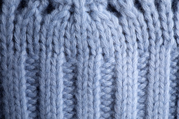 Blue knitted sweater as background, closeup view