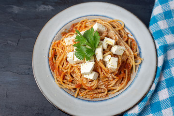 Spaghetti pasta with fresh and parmesan cheese on dark background