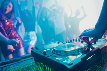 Dj playing performing stereo sound rhythm trance techno style set for attractive stylish cheerful positive people crowd having fun weekend festive concert at fashionable modern nightclub