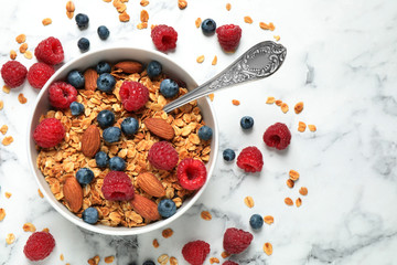 Tasty homemade granola with berries on white marble table, top view. Healthy breakfast
