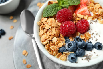 Tasty homemade granola with yogurt and berries on grey table, closeup. Healthy breakfast - obrazy, fototapety, plakaty