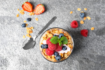Obraz na płótnie Canvas Glass of tasty homemade granola dessert on grey table, flat lay. Healthy breakfast
