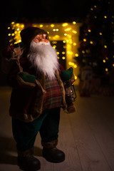 Obraz premium Santa Claus carrying big bag full of gifts, at home near Christmas Tree