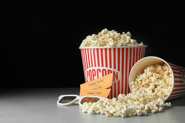 Popcorn, cinema tickets and 3d glasses on grey table. Space for text