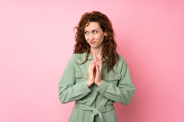 Young pretty woman over isolated pink background scheming something