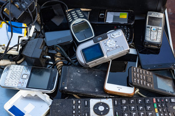 Close up on pile of mixed electronic waste, old broken computer parts and cell phones