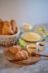 Tasty and healthy breakfast, natural cottage cheese, fresh croissant with honey. Morning still life. Bakery products.