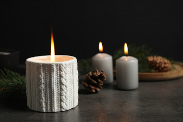 Fototapeta na wymiar Candle and Christmas decor on dark grey table, space for text