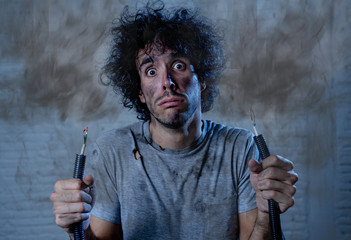 Funny image of man holding electrical cable after getting electric shock