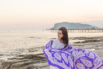 Fototapeta na wymiar Portrait of female dancing with silk scarf at the beach