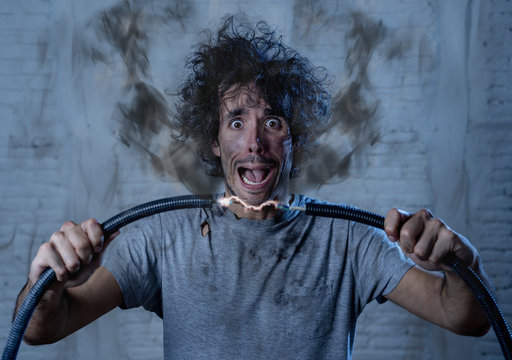 Funny image of man getting electric shock with funny face and smoke all around. DIY concept