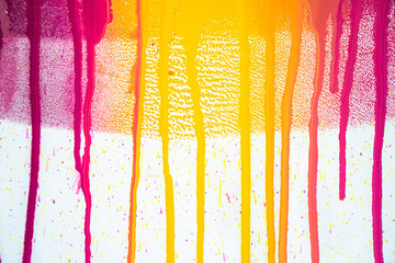 colors of printing ink purple, pink, orange, yellow and magenta colors are dripping on white paper.