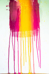 colors of printing ink purple, pink, orange, yellow and magenta colors are dripping on white paper.
