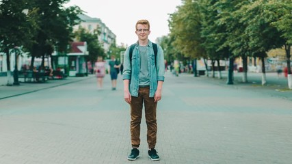 Time-lapse of handsome young man standing in the street of big city and looking at camera with people moving around. Urban lifestyle and society concept.