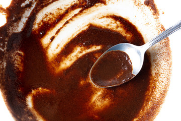 Coffee stains in with a spoon on a white plate