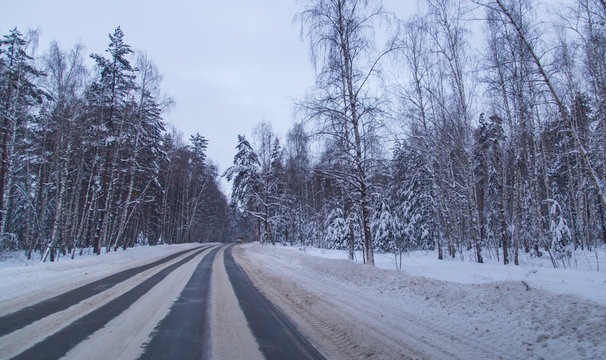 Asphalt road in the forest covered with snow