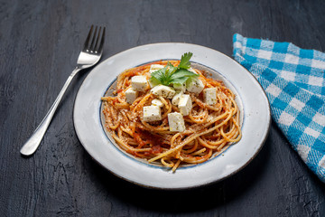 Spaghetti pasta with fresh and parmesan cheese on dark background