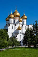 Fototapeta na wymiar Russia, Golden Ring, Yaroslavl: Famous onion domed Virgin Mary Ascension Church Cathedral (Maria-Entschlafens-Kathedrale) in the center of the Russian town with people, trees, blue sky.