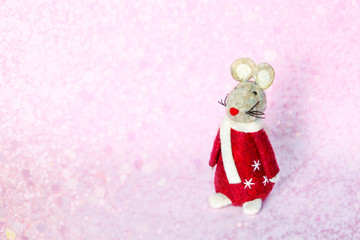 Cute mouse toy on blurred christmas background with lights bokeh. Xmas rat is symbol of New year 2020 according to Chinese calendar.