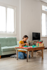 Woman wrapping handmade craft gifts on the table at home