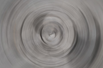 Fototapeta na wymiar Blurred radial motion gradient dark gray background. Circular brushed texture