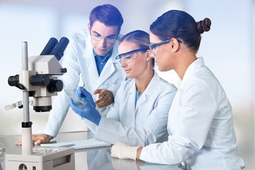 Female and male scientists in glasses working with microscope