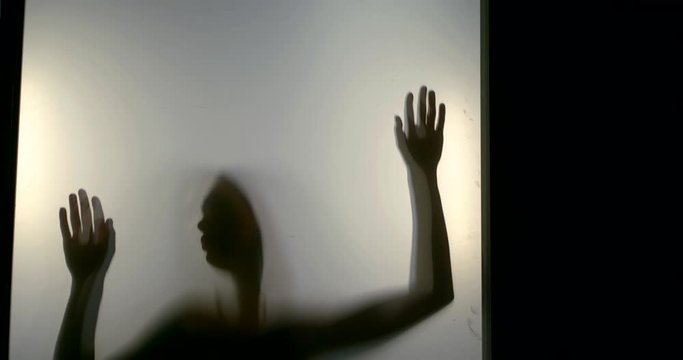 woman hands slide down matte screen in backlight slow motion
