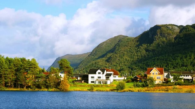 Alesund, Norway. View of the typical houses by the mountain and lake in Alesund, Norway during a sunny autmn day with cloudy sky