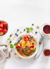 pancakes with blueberry strawberry honey and nuts for breakfast
