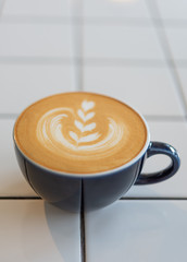 Latte art coffee cup on white table