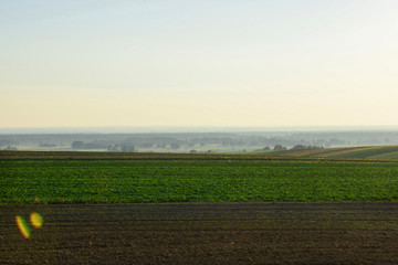 View of farmlands, cities and villages bathed in the glow of the setting sun.