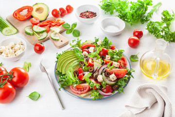 greek style avocado tomato salad with feta cheese, olives, cucumber, onion, lettuce