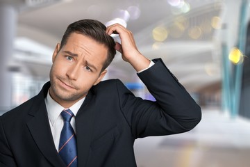 Young businessman scratching his head, hard decision