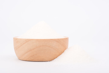 White granulated sugar contain in brown wooden bowl on white background. Unhealthy food concept.