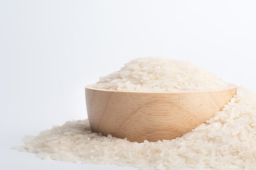 Clean rice grain in a brown wooden bowl on a white background.