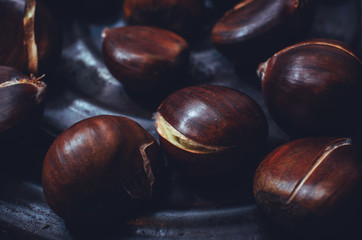 Grilled chestnuts in a pan closeup.
