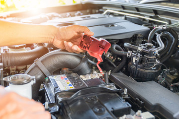 Selective focus, Technician man hand checking car battery on car engine system - obrazy, fototapety, plakaty